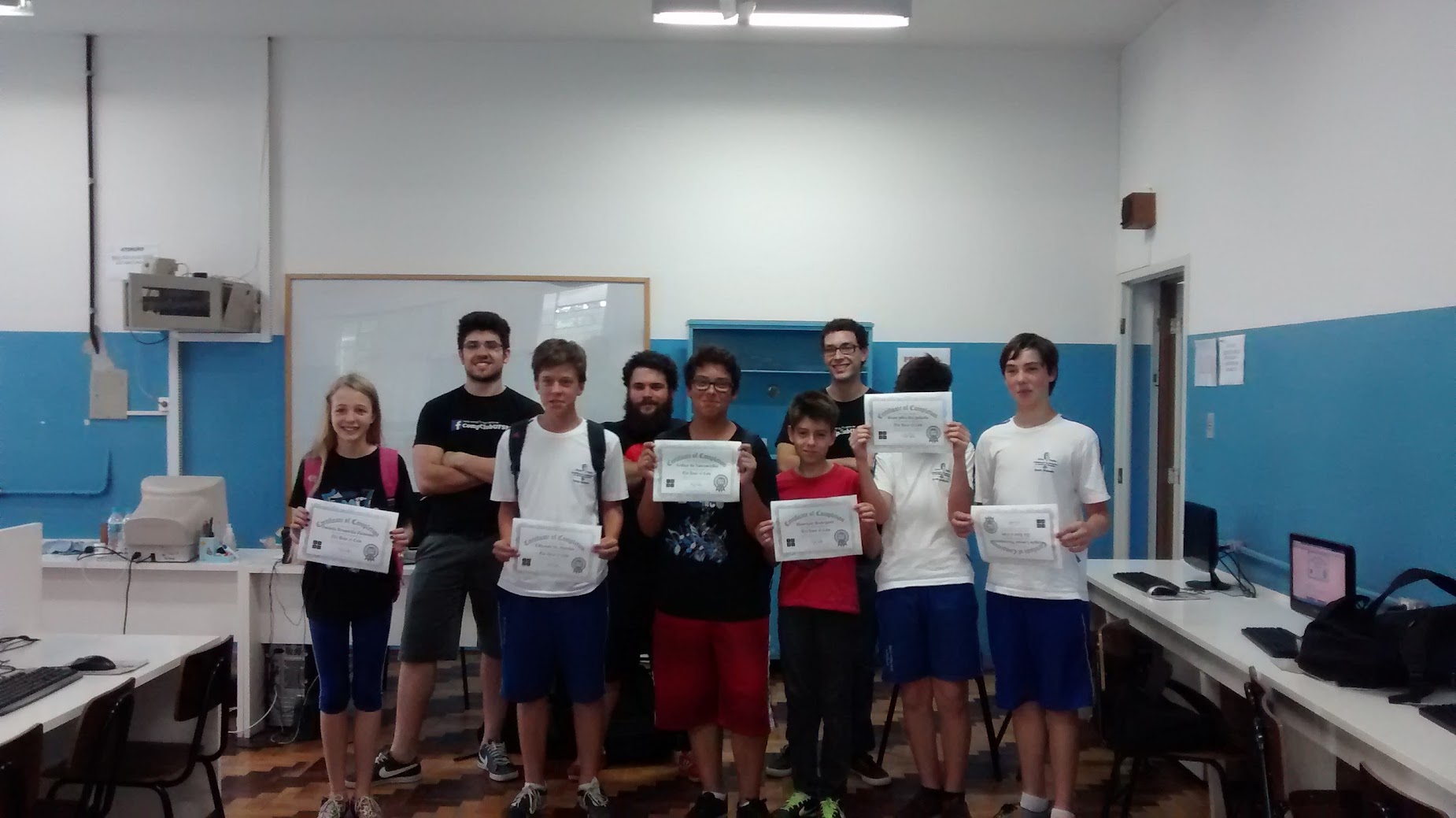 A class of kids receiving a certificate for participating in the Computation Club.