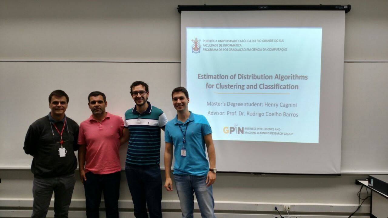 Four men standing in front of a slide presentation.